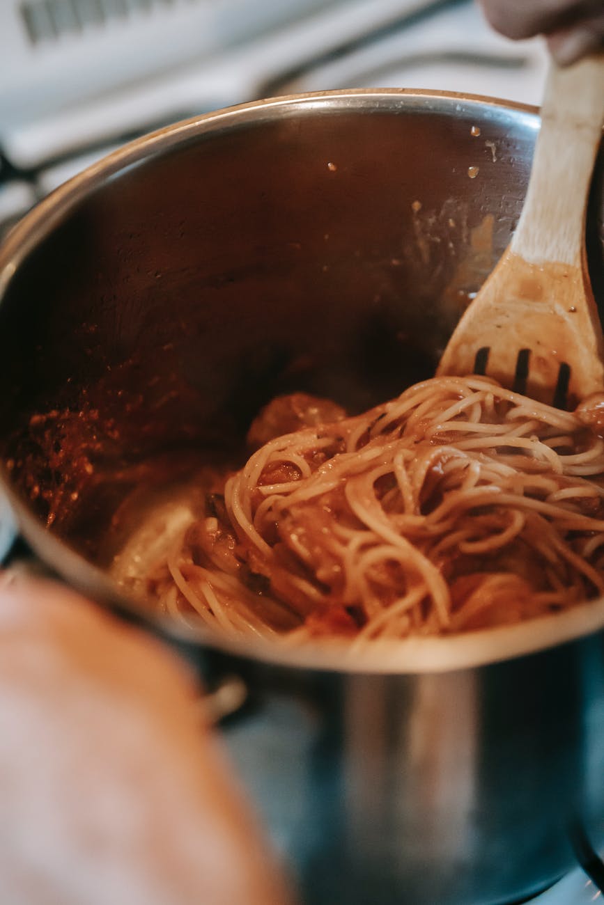 yummy pasta with tomato sauce in metal saucepan